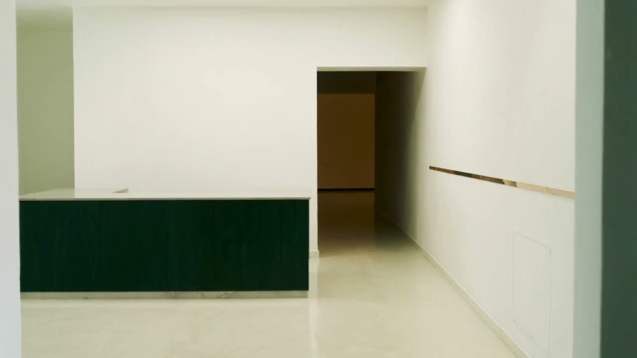 Sanfter Vorwärtsflug an einem aufgeräumten Empfang vorbei in einen ruhigen Korridor, ohne Schwenks.